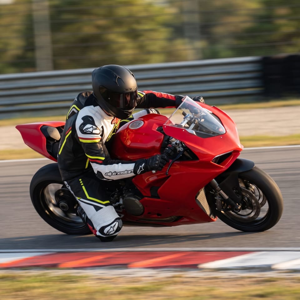 Mono Alpinestars Rojo/Blanco Asimétrico: piloto en pista con el equipo puesto