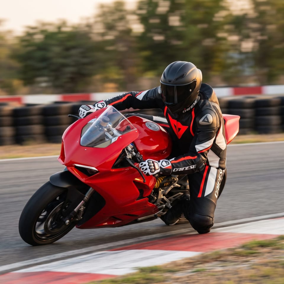 Mono Dainese Negro/Rojo Flúor + Guantes: piloto en pista con el equipo puesto