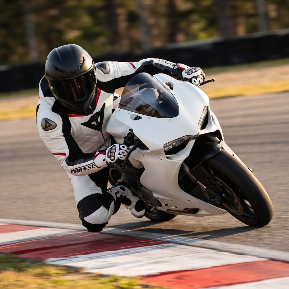 Set Dainese Blanco/Negro: piloto en pista con el equipo puesto