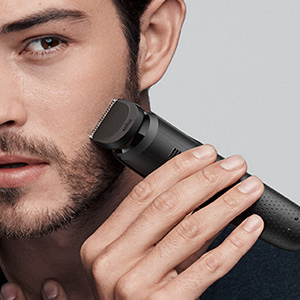 Man shaving face with braun trimmer