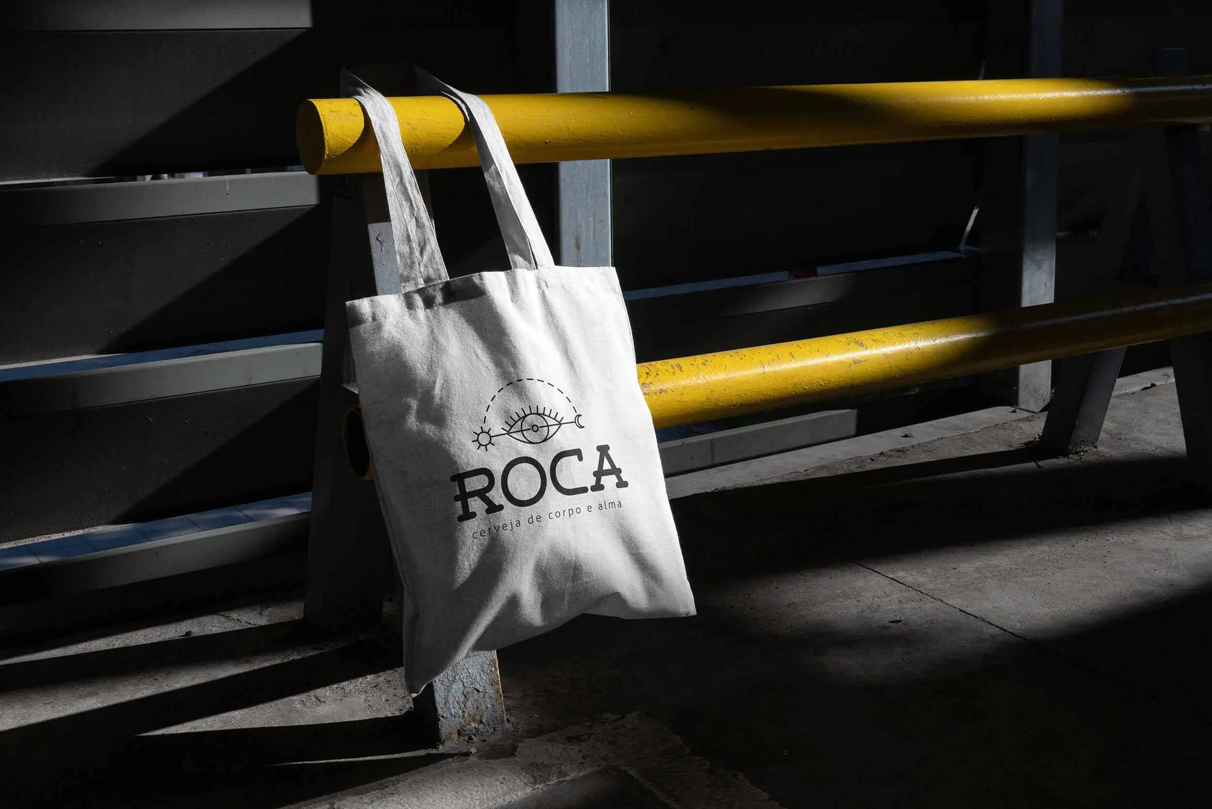 ROCA craft beer branded canvas tote on an urban yellow railing