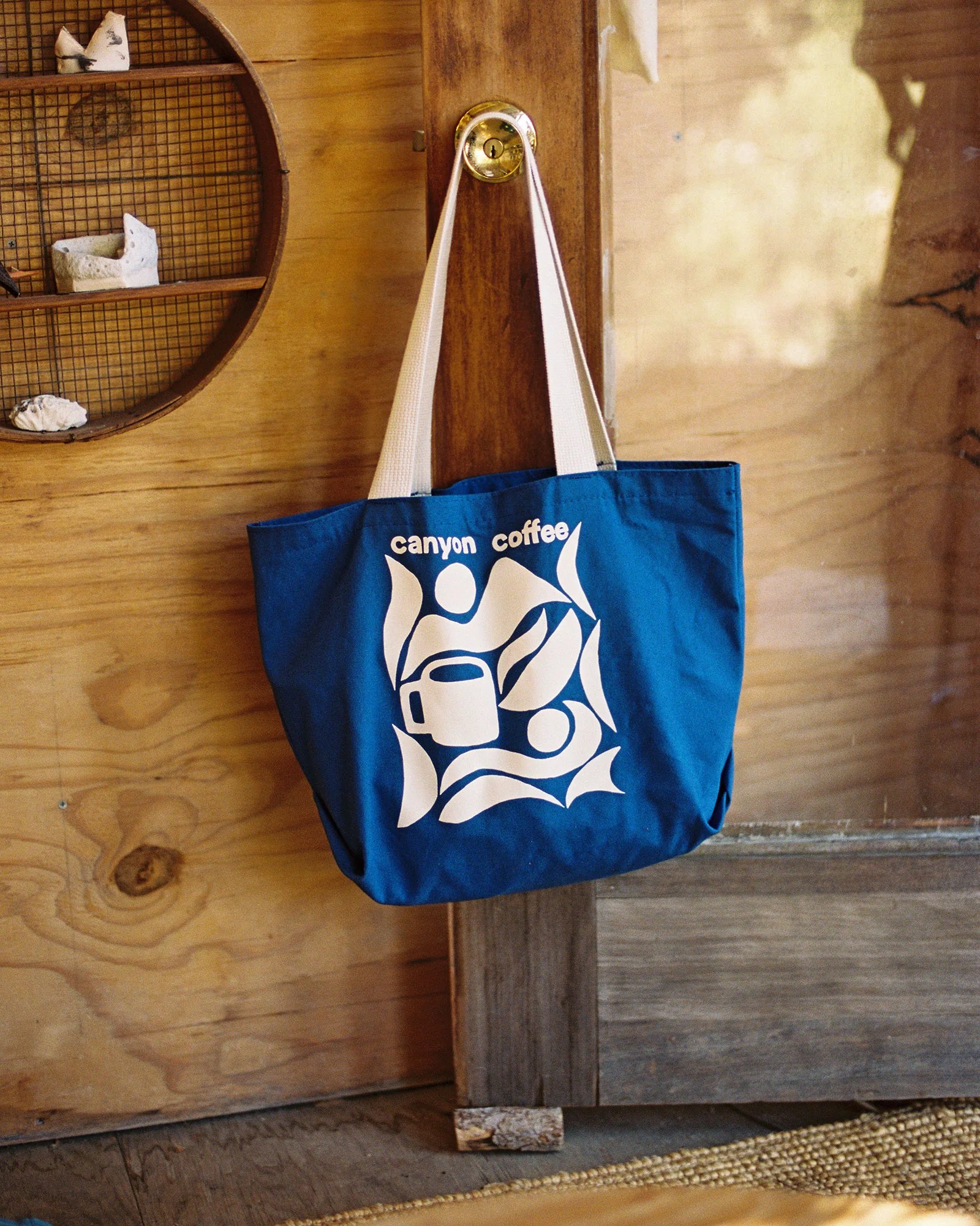 Screen-printed white branding on a blue canvas tote bag
