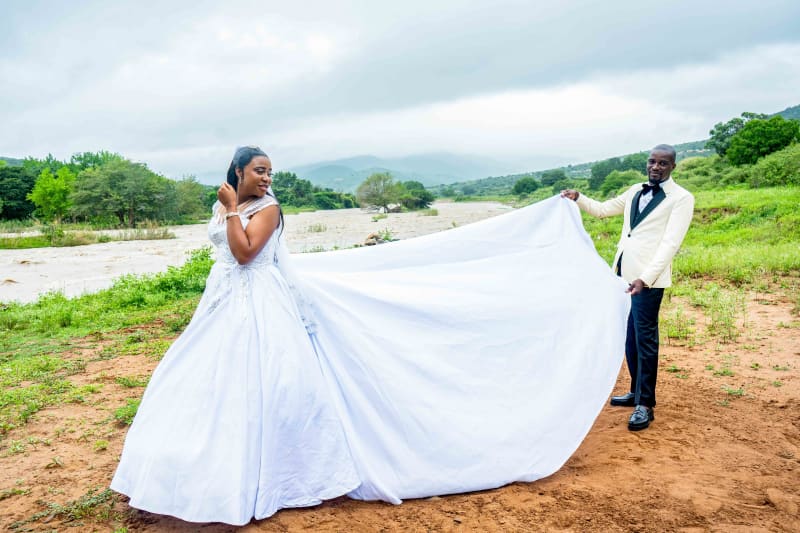 The groom showing off his wife's majestic dress