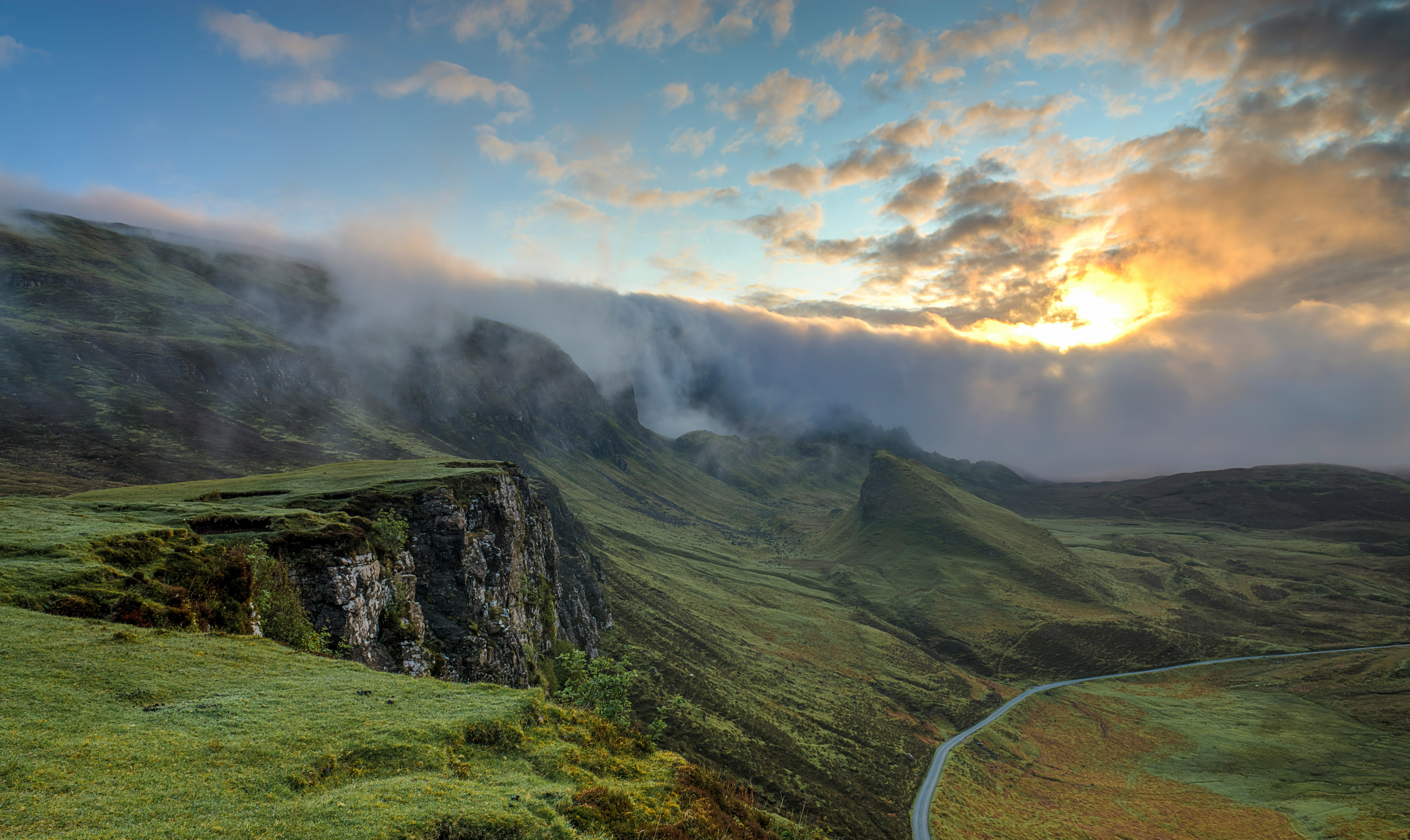 Foggy cliffs with hills below.