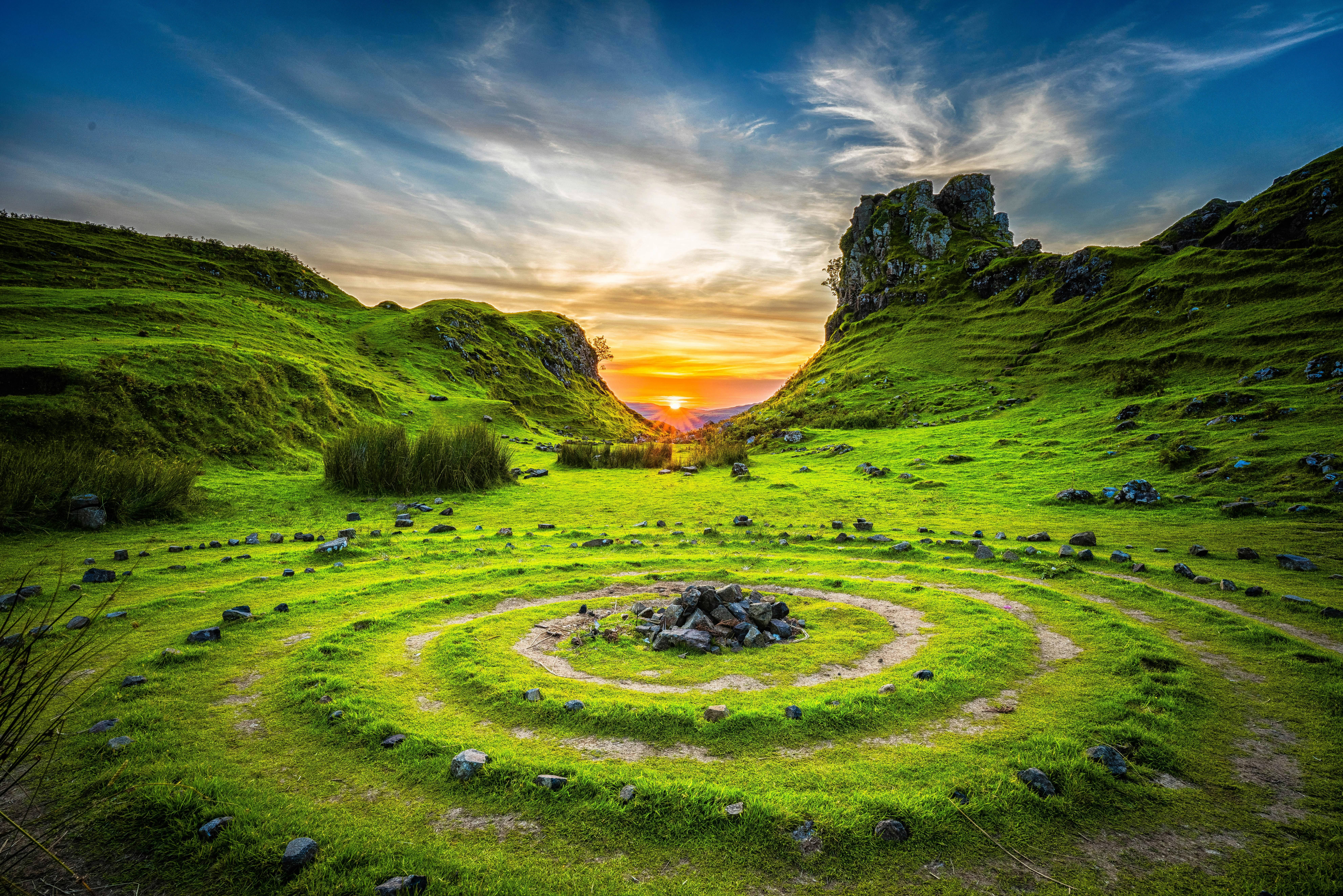Some rocks in a large spiral ring, with a sunset in the background.