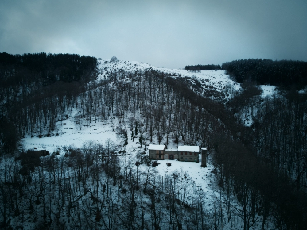 Immagine aerea di una fattoria abbandonata in mezzo alla neve.