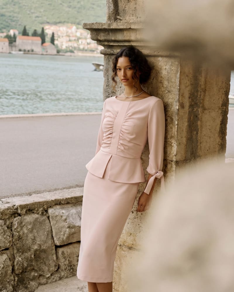Vestido rosa empolvado con detalle fruncido junto al mar, fotografía ecommerce con integración IA