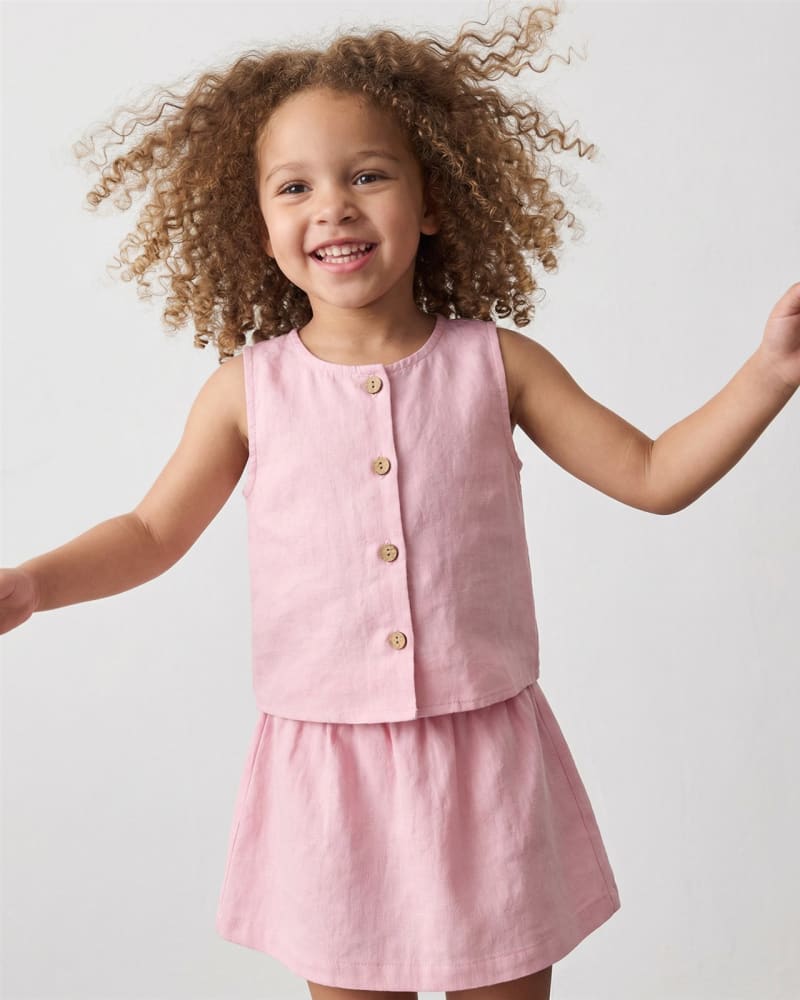 Conjunto infantil de lino rosa con top y falda, fotografía ecommerce de moda kids con modelo IA