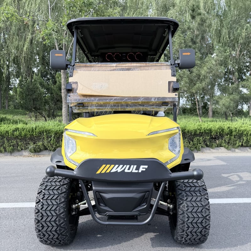 Yellow Wulf golf cart photographed head-on, showing the brush bar and badge