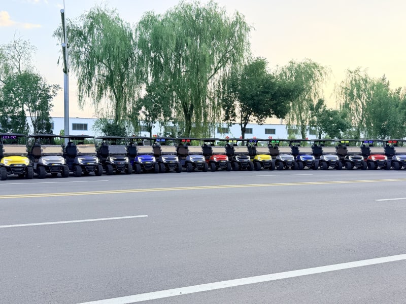 Row of Wulf golf carts parked under willow trees at dusk