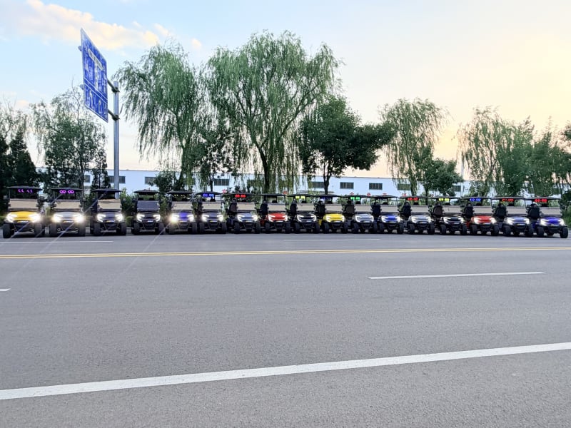 The row of Wulf golf carts with headlights on as the light fades
