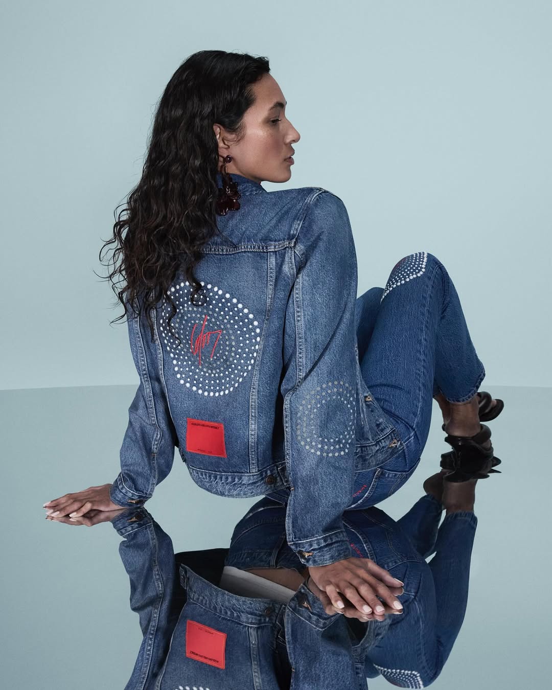Capsule collection — female model, back view with COLORS x Levi's artefact
