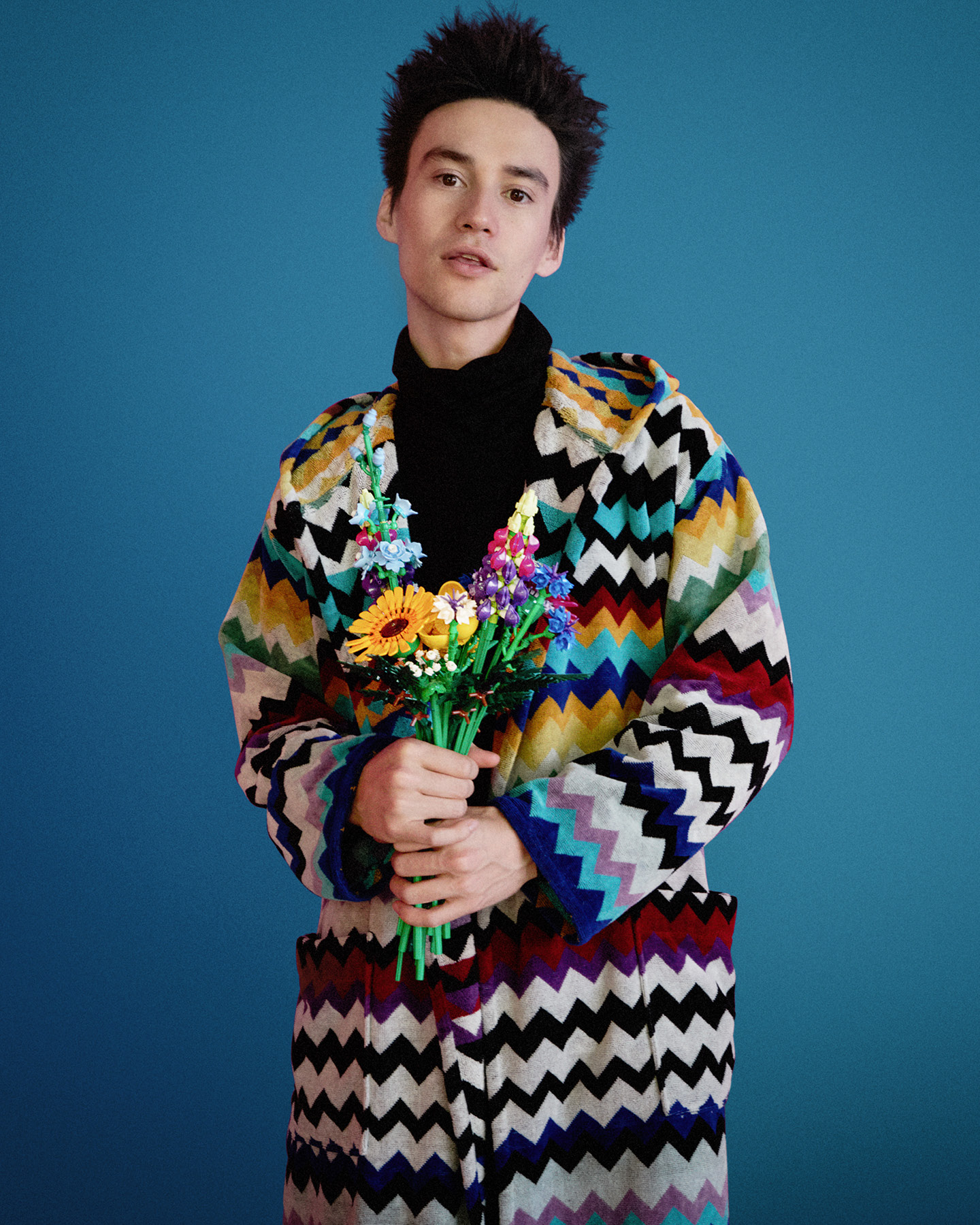 Jacob Collier holding a LEGO Botanical bouquet, the product appearing inside the performance world rather than alongside it