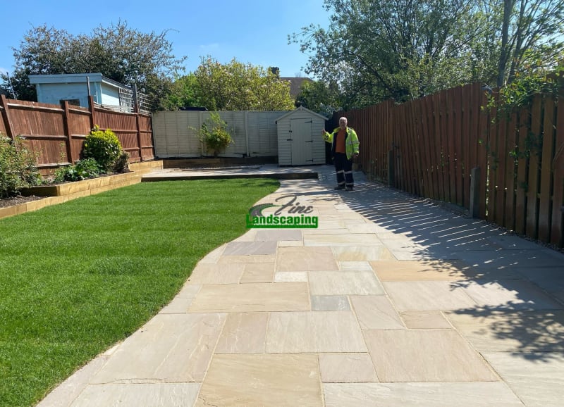 Stone paving around a lawn and raised beds in Orpington