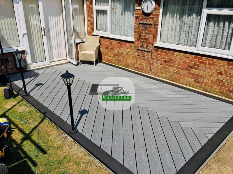 Grey decking outside rear doors with a step down to grass
