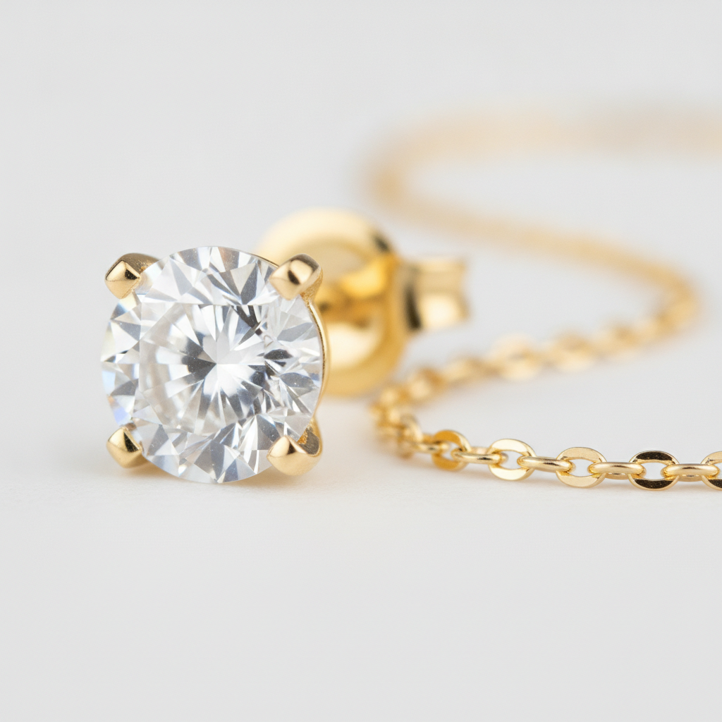 Macro detail of diamond stud earring prong setting beside fine gold chain – diamond earrings and necklaces pairing detail