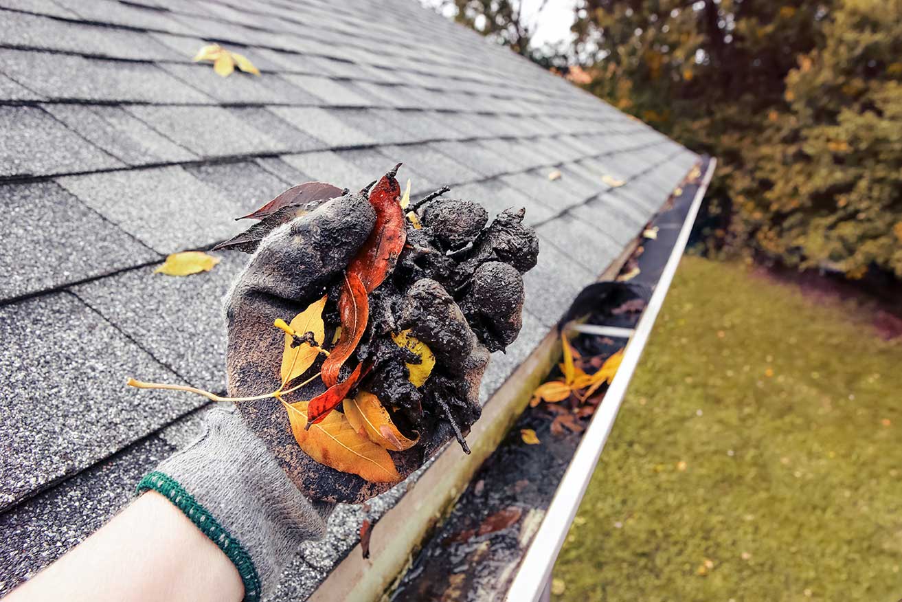 Professional gutter technician performing comprehensive fall preparation and winter readiness inspection