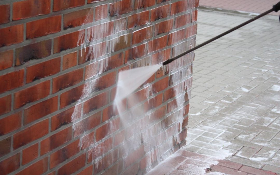 Professional technician demonstrating proper brick and stone cleaning techniques with appropriate equipment