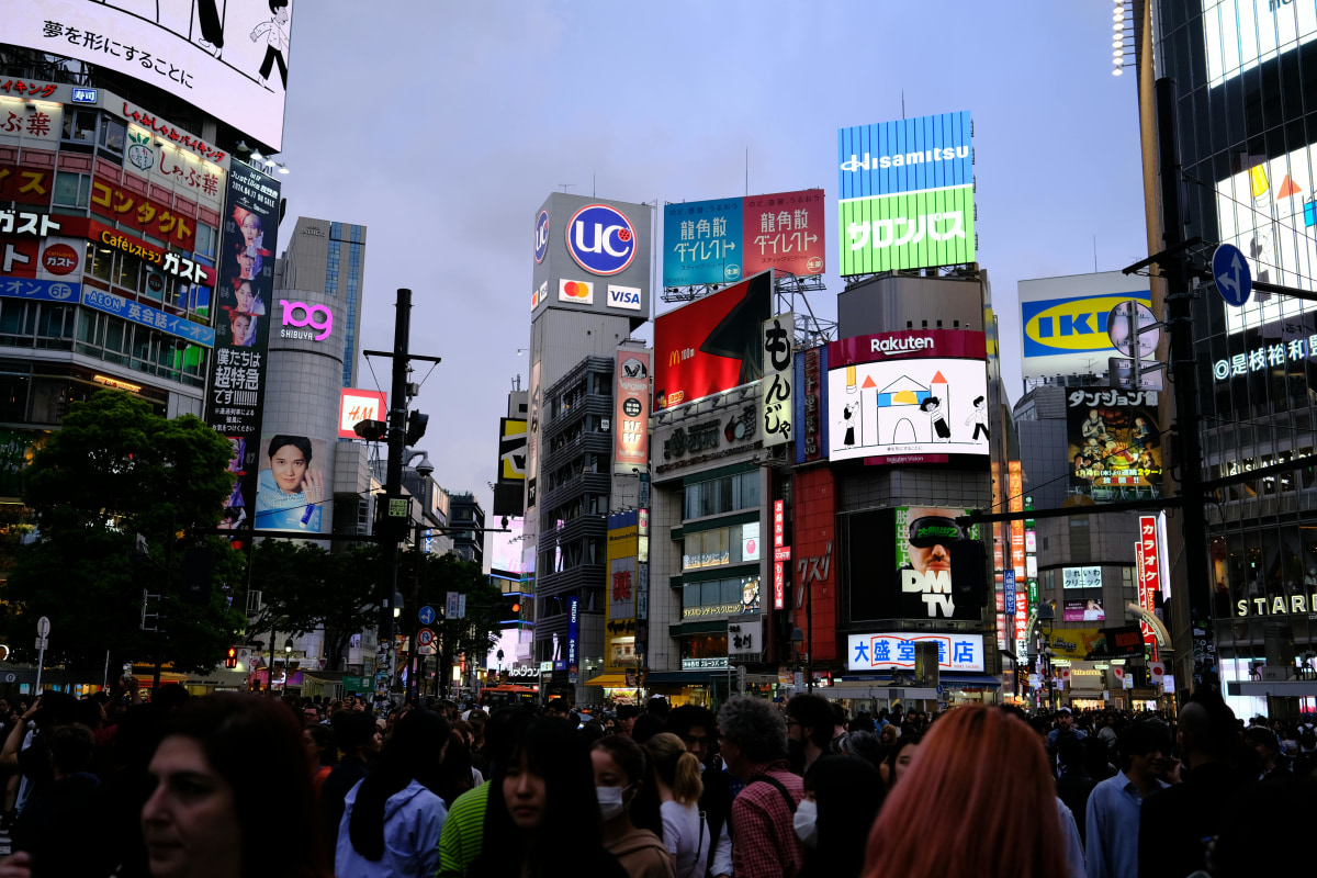 Bustling street scene at Shibuya Crossing, a famous urban landmark in Tokyo, Japan, at night.