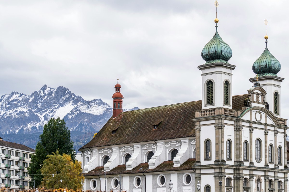 Stunning view of the Jesuit Church in Lucerne against the majestic Swiss Alps.
