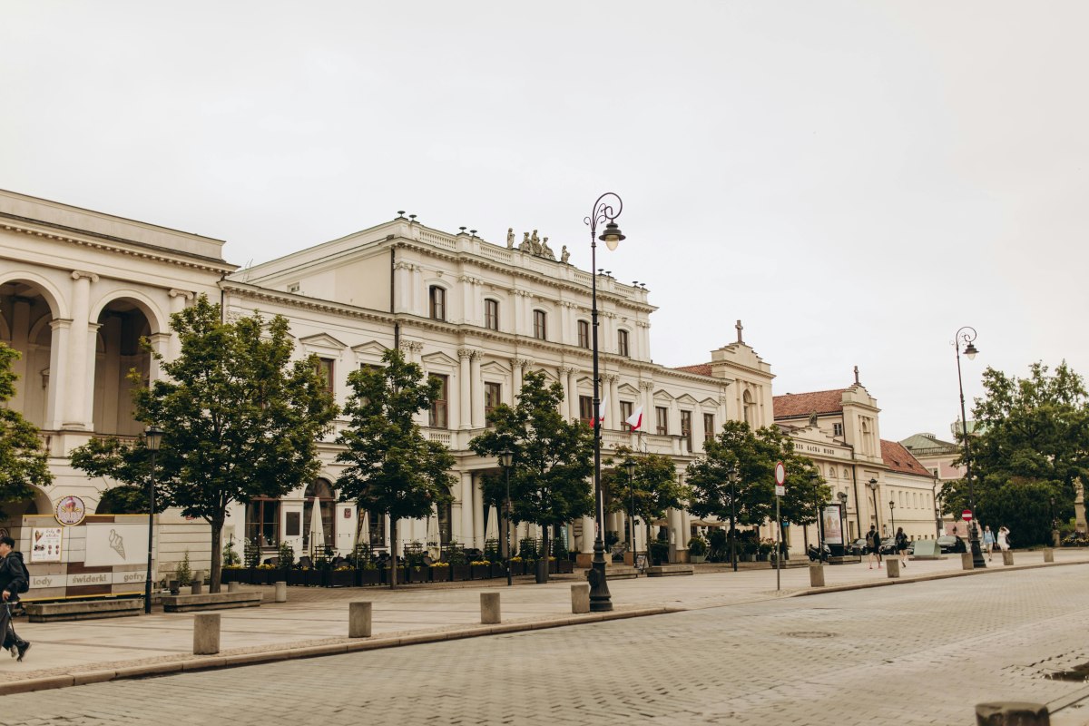 A view of Polonia House on a quiet street in Warsaw, Poland, showcasing historic architecture.