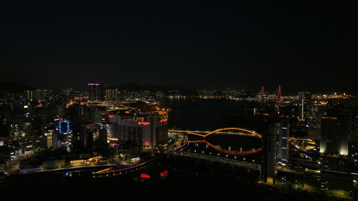 Stunning night view of Busan city skyline featuring illuminated bridges and skyscrapers.