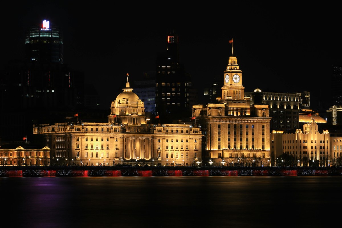 Night view of The Bund in Shanghai showcasing iconic historical buildings beautifully lit up.