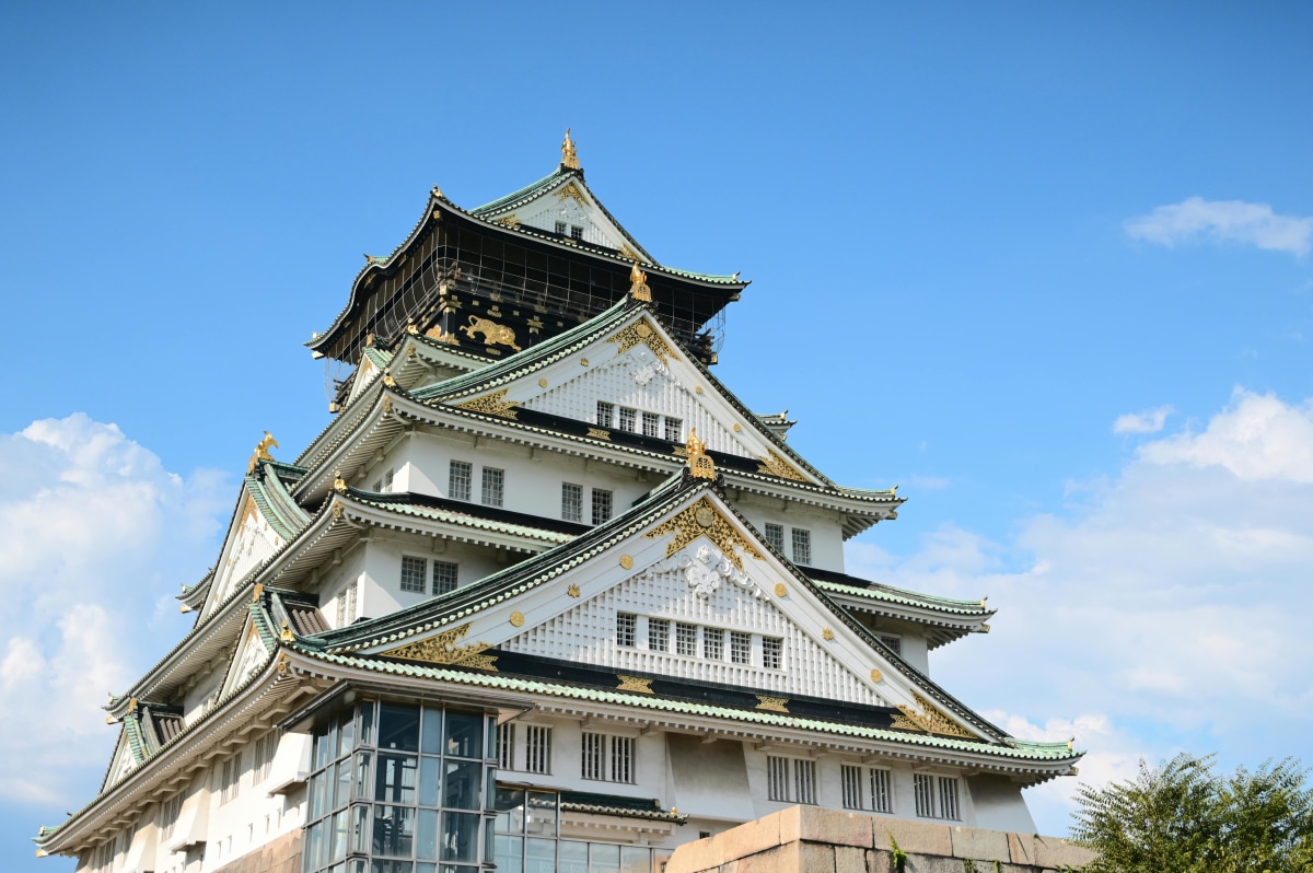 Osaka Castle on a clear day with cherry trees in the foreground