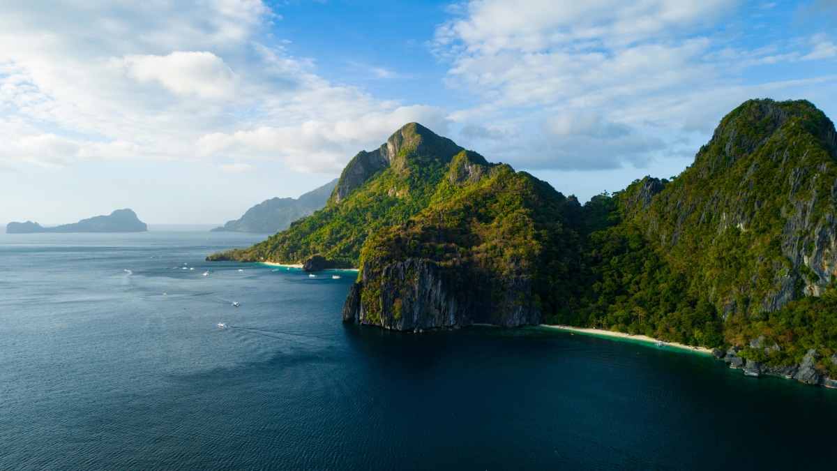 Breathtaking aerial view of El Nido, Philippines with lush islands and azure waters under a clear sky.