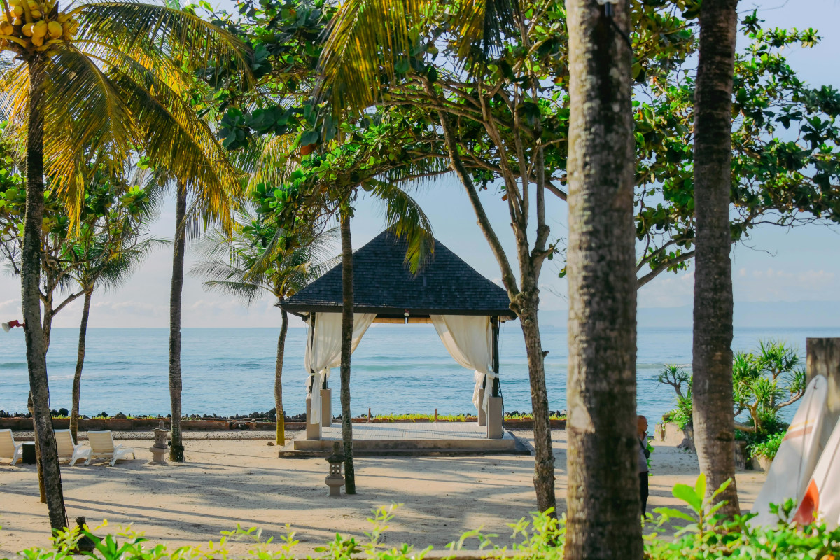 Bali tropical pavilion with palm trees by beach