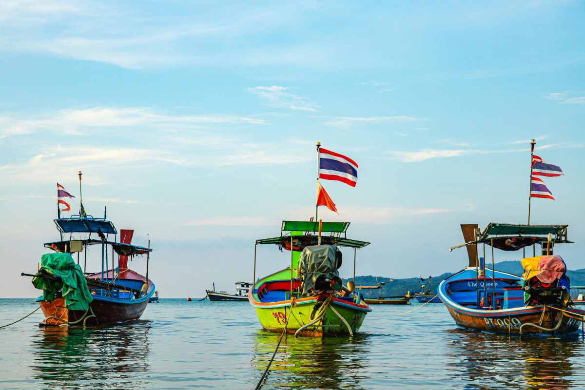 Colorful fishing boats with Thai flags in Phuket waters