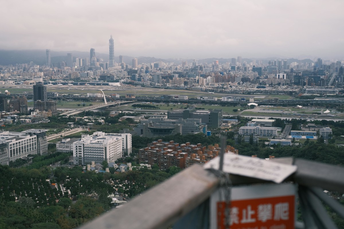 象徴的な台北101の超高層ビルを擁する台北の広大な街並みの空撮。