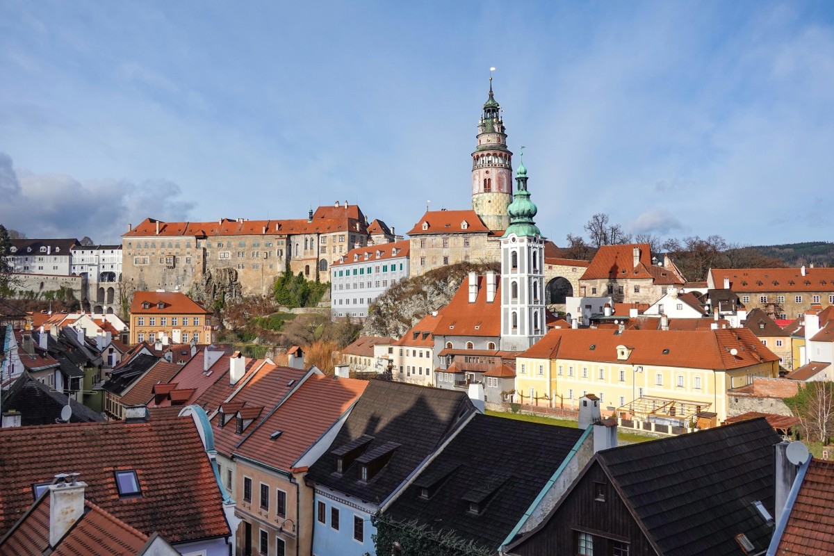 A picturesque view of Český Krumlov Castle and the historic old town under a clear blue sky.
