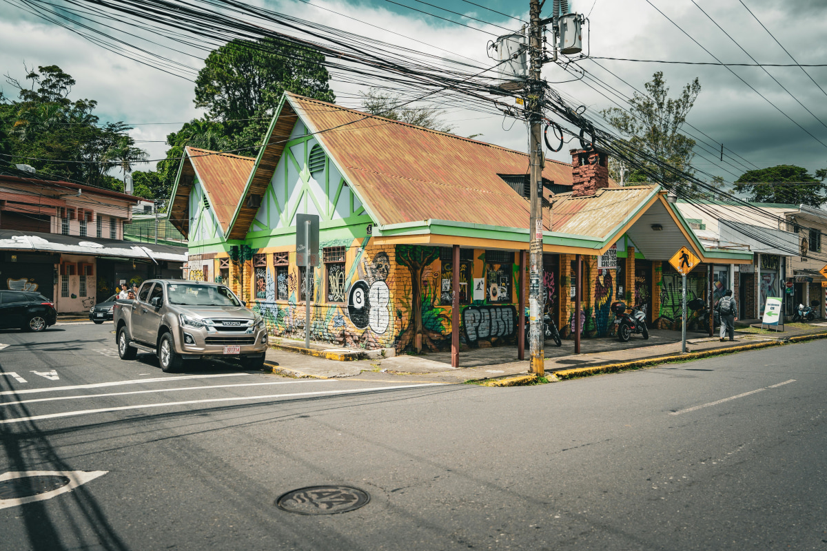 Street view of a colorful building with graffiti in San José, Costa Rica on a sunny day.