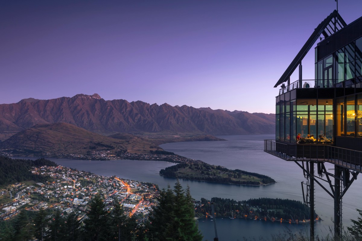 Stunning aerial view of Queenstown, New Zealand at twilight with Lake Wakatipu and Remarkables in the background.