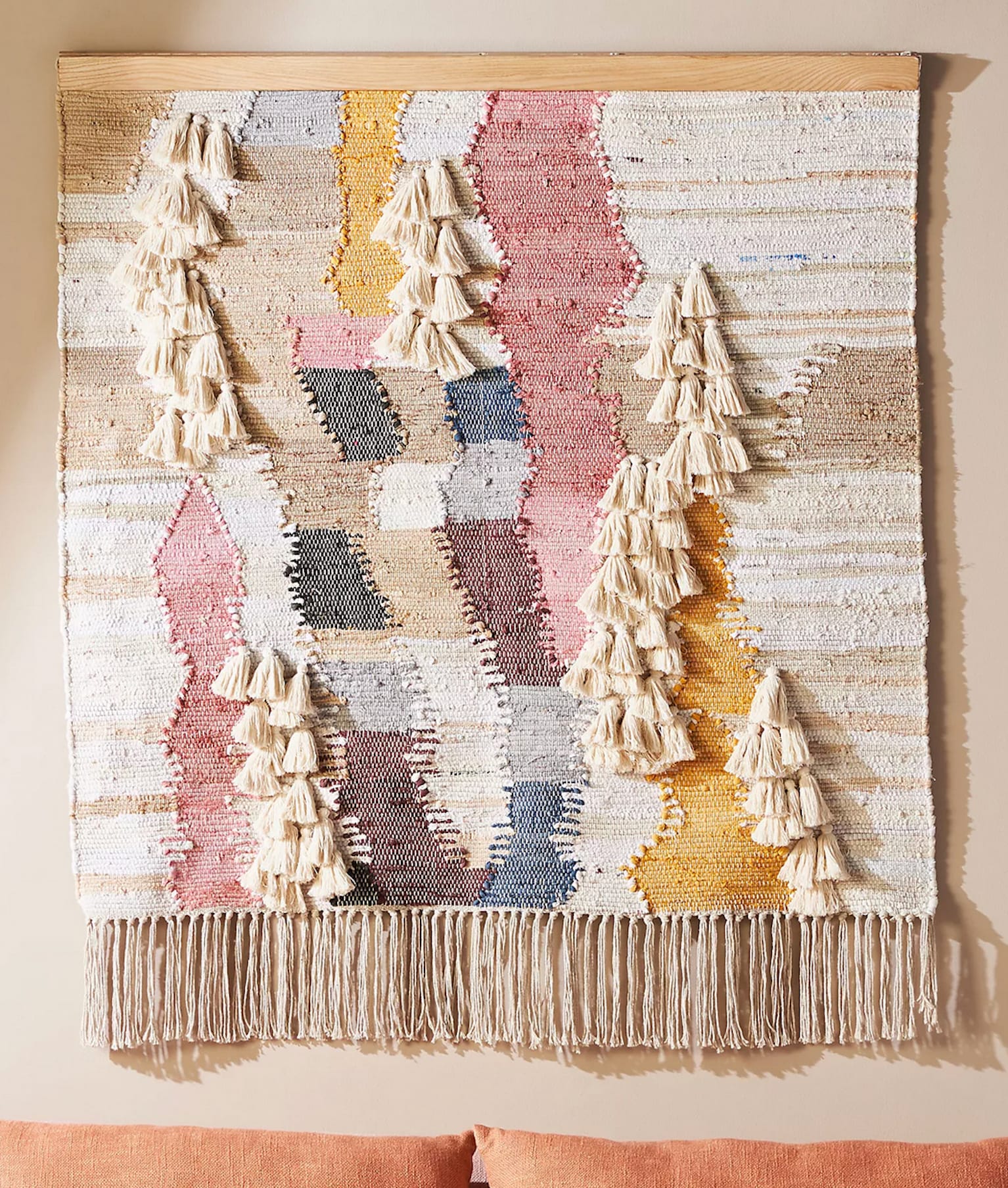 Handcrafted wall decoration in weaving, with tassels and fringes.