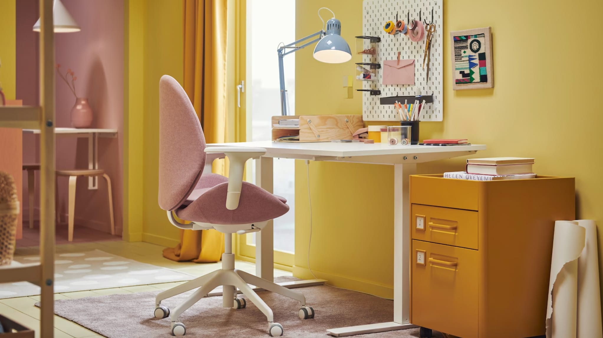 Bureau à la maison, murs jaunes, table de travail, chaise à roulettes rose