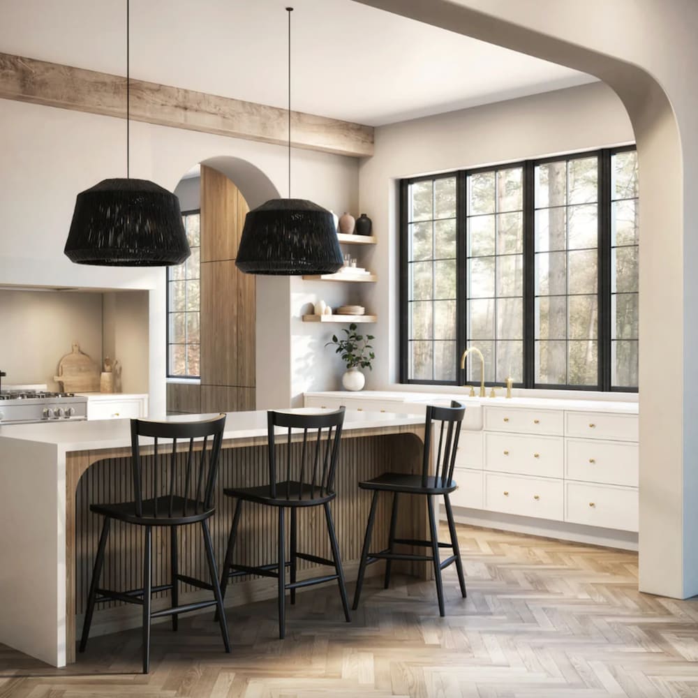 Cuisine de style ferme, avec îlot et trois chaises hautes en bois noir, avec dossier à barreaux