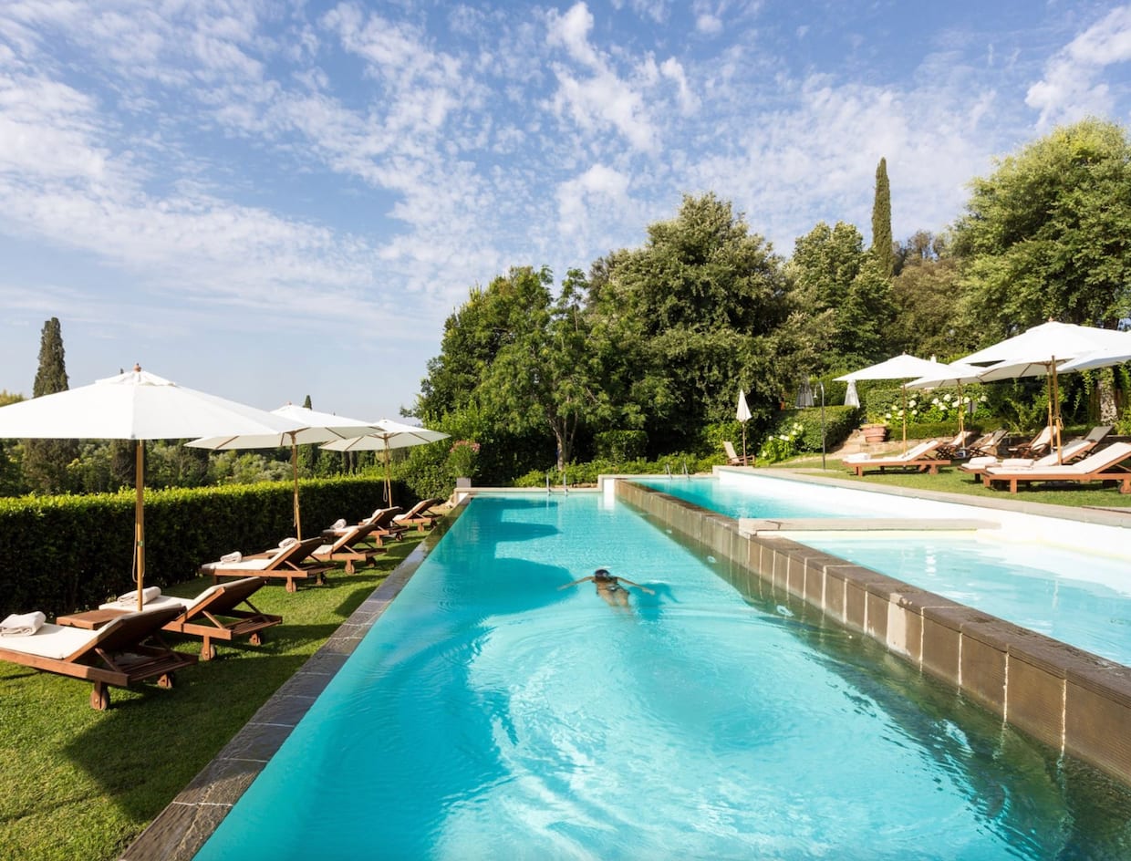 Belles piscines deux couloirs étroits côte à côte, jardin gazon, chaises longues et parasols crème