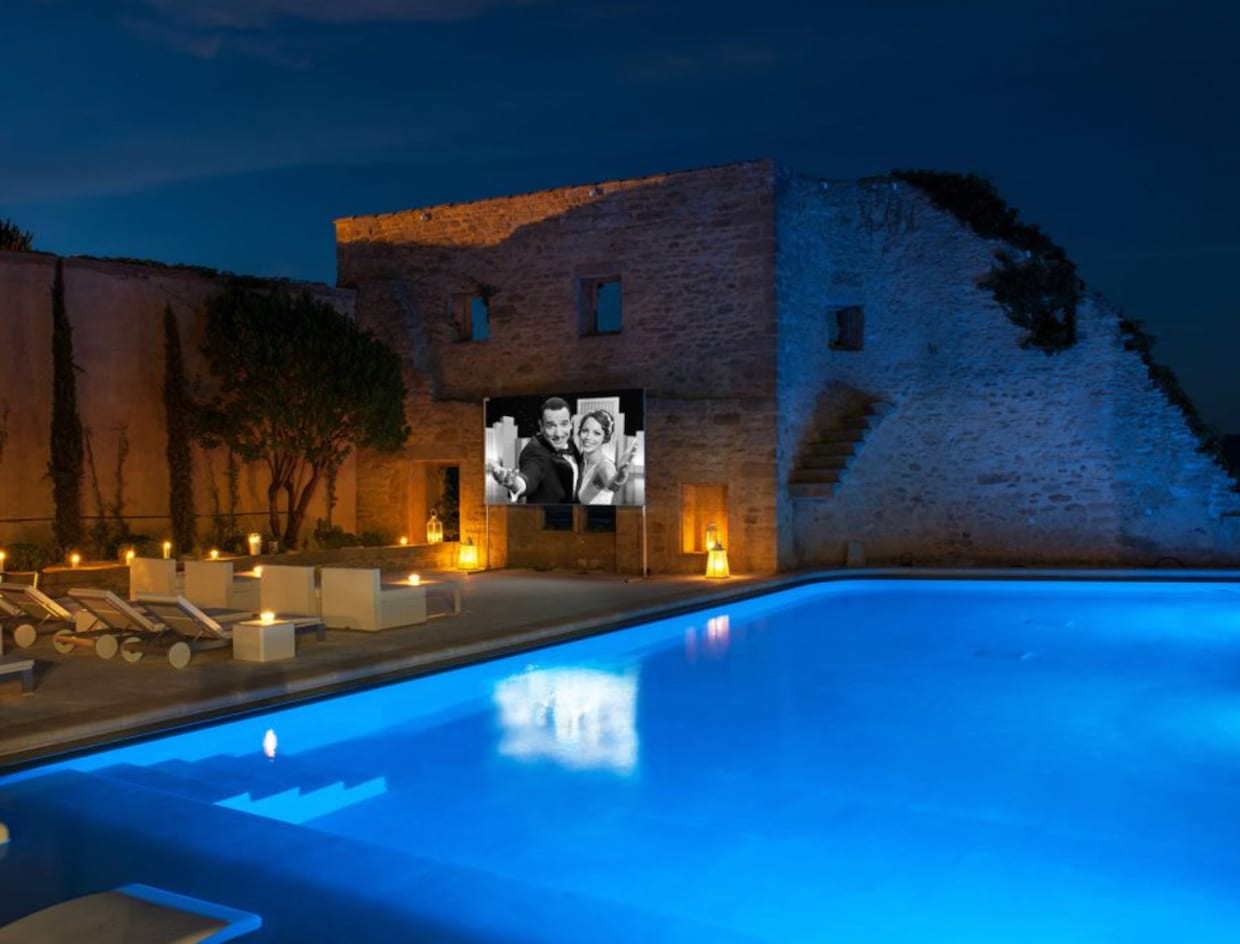 Belles piscines nuit terrasse illuminée, projection film noir et blanc sur écran extérieur