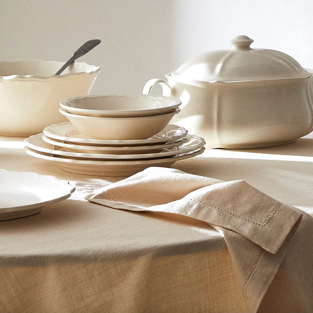 Déco voyage service de vaisselle en faïence blanc crème sur une nappe en lin beige