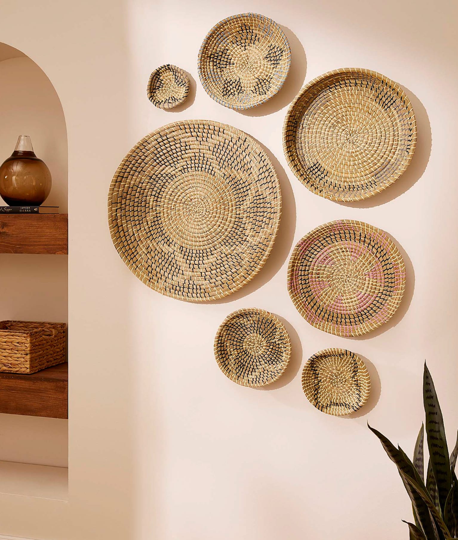 Déco voyage sept paniers tressés de grandeurs différentes accrochés sur un mur