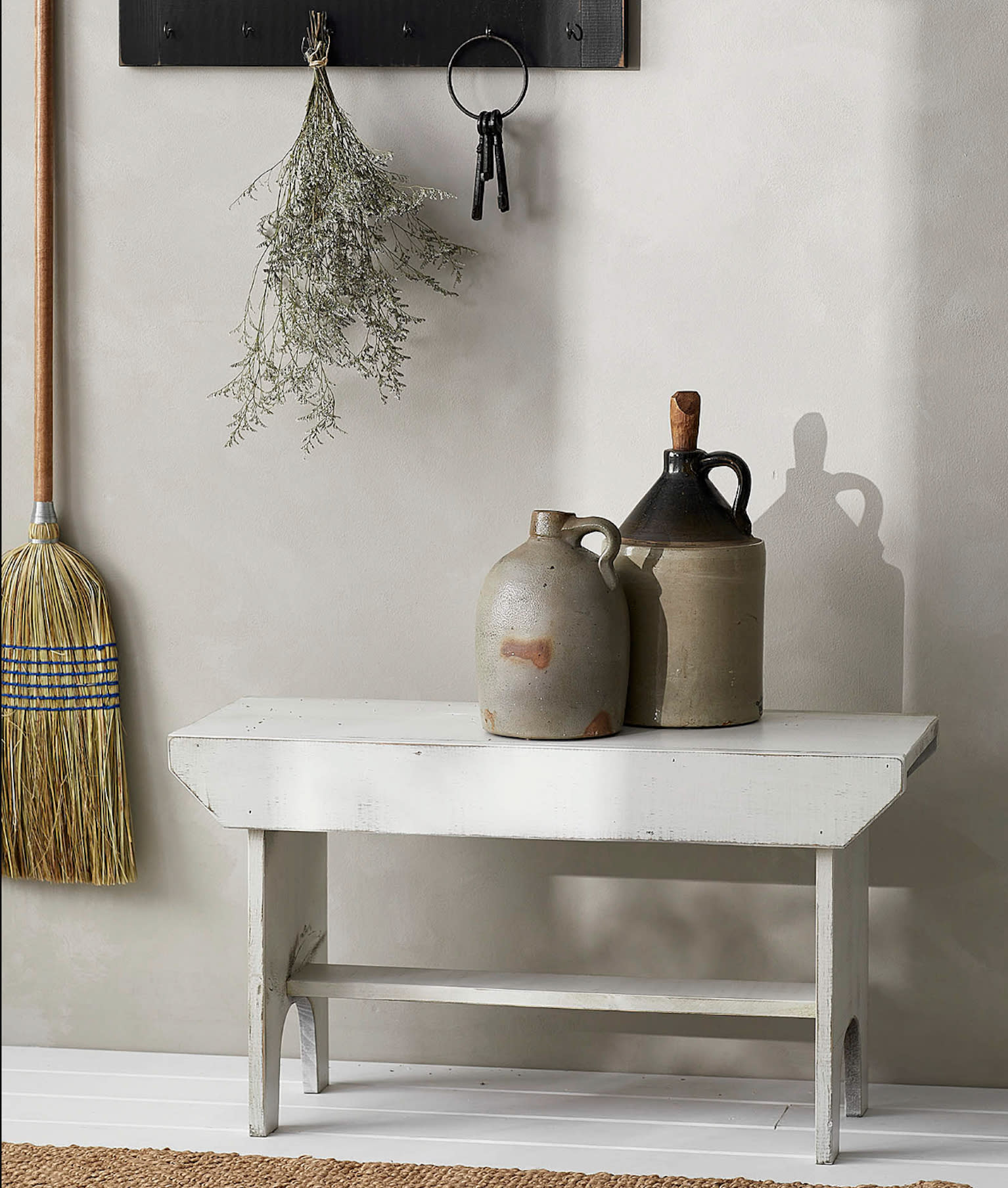 Déco voyage, banc vintage en bois peinturé en blanc, jarres en grès, bouquet de fleurs séchées et trousseau de vieilles clés accrochés au porte-manteaux