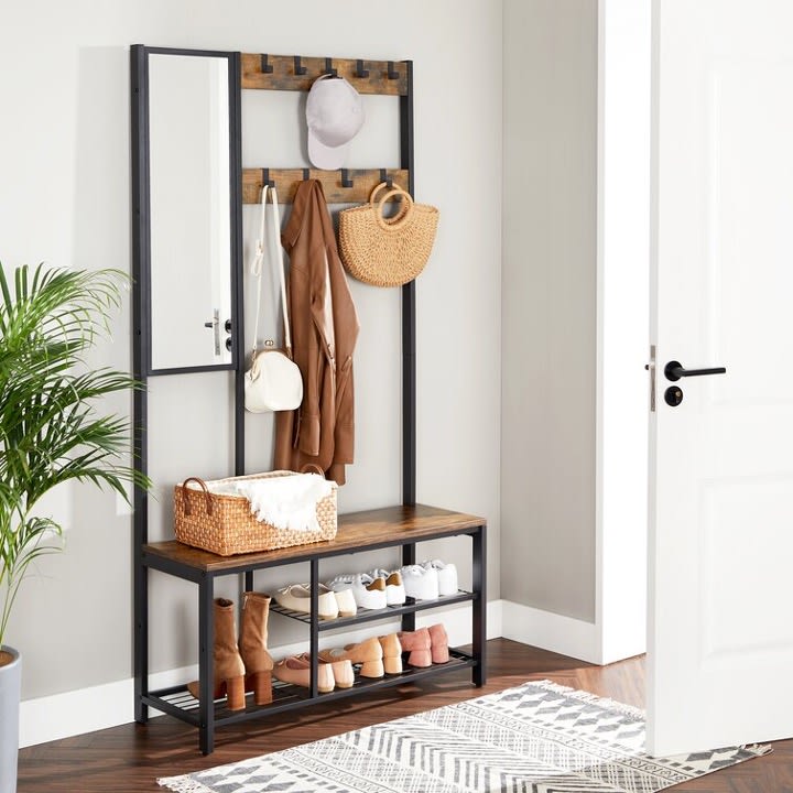 Meuble d'entrée comprenant un miroir, des crochets, un banc et un espace où déposer les souliers