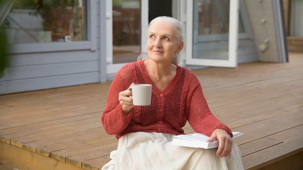 Woman sitting with cup of coffee, looking outside