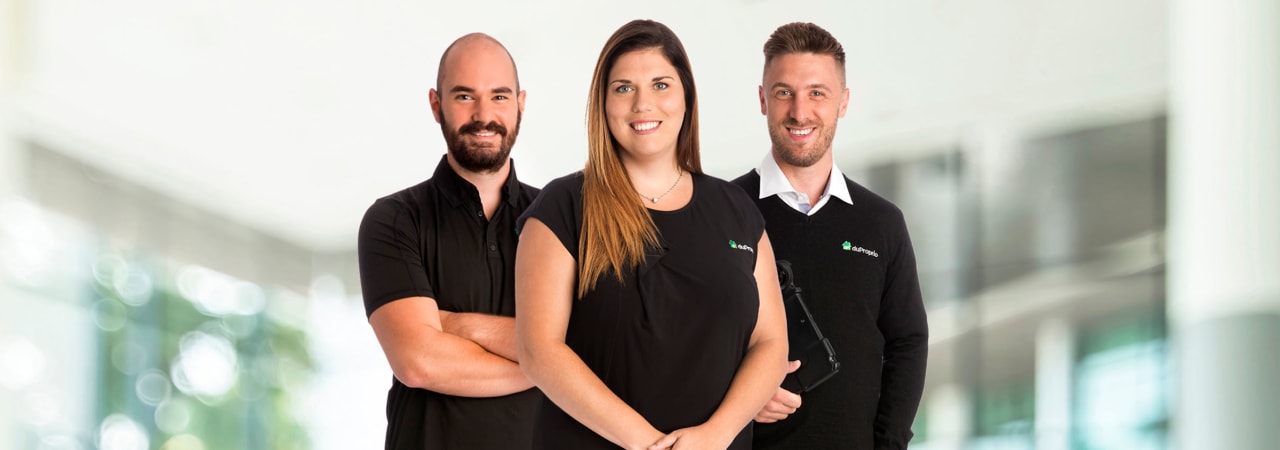 Three DuProprio employees standing up facing the camera