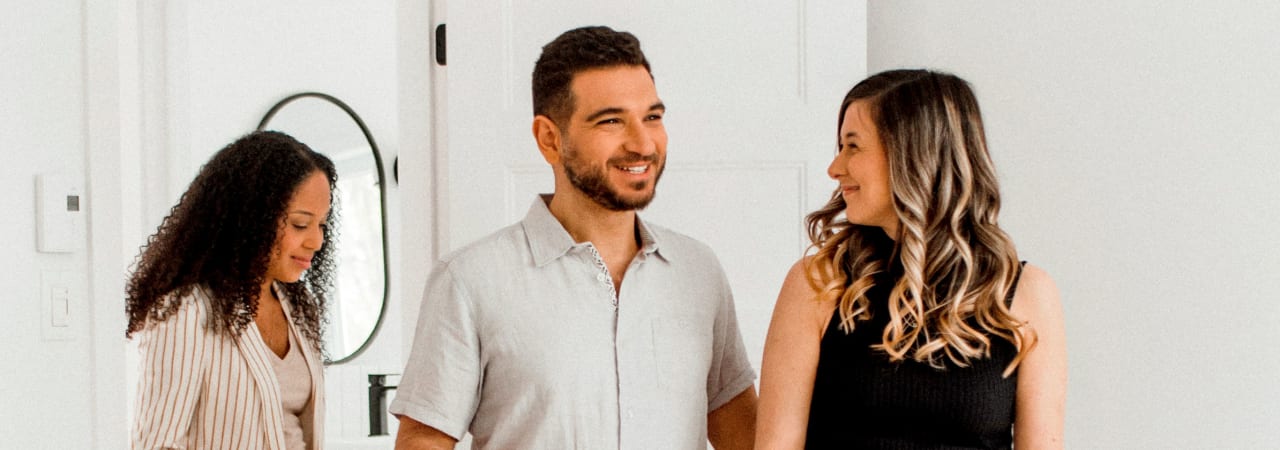 Un couple qui visite une maison en compagnie d'une courtière immobilière