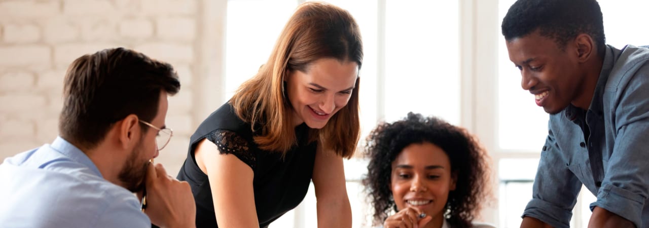 Quatre collègues qui travaillent en collaboration autour d’une table