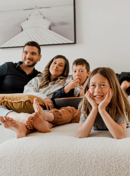 Famille avec deux enfants installés dans le canapé de leur nouvelle maison