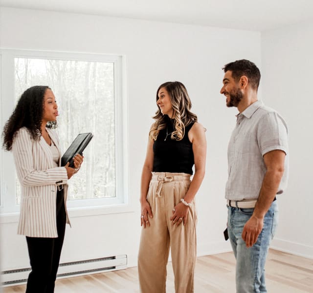 Couple accompagné d’une courtière immobilière lors d’une visite